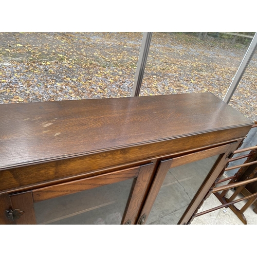 1827A - AN EARLY 20TH CENTURY OAK TWO DOOR BOOKCASE ON CABRIOLE LEGS