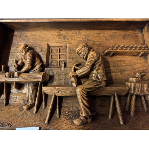 21 - A SIGNED WOODEN CARVED PICTURE DEPICTING CARPENTERS AT WORK