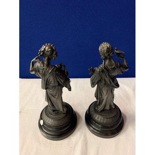 28 - A PAIR OF SPELTER FIGURINES ON POLISHED WOODEN BASES