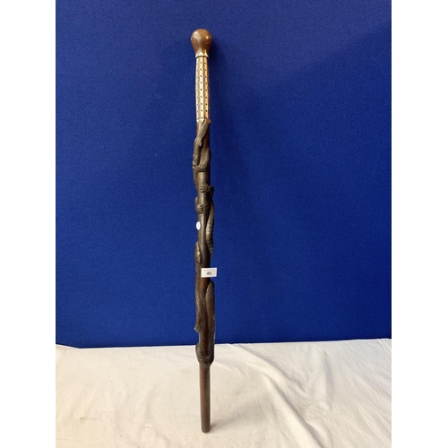 40 - AN INTRICATELY CARVED WOODEN STICK WITH MOTHER OF PEARL STYLE DETAIL AND CROCODILE AND SNAKE DESIGN