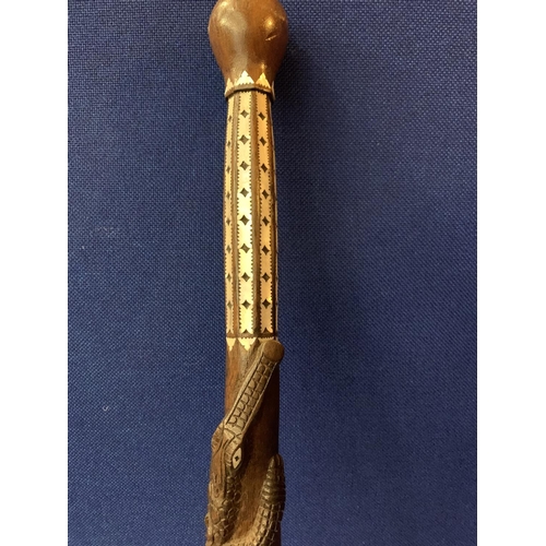 40 - AN INTRICATELY CARVED WOODEN STICK WITH MOTHER OF PEARL STYLE DETAIL AND CROCODILE AND SNAKE DESIGN