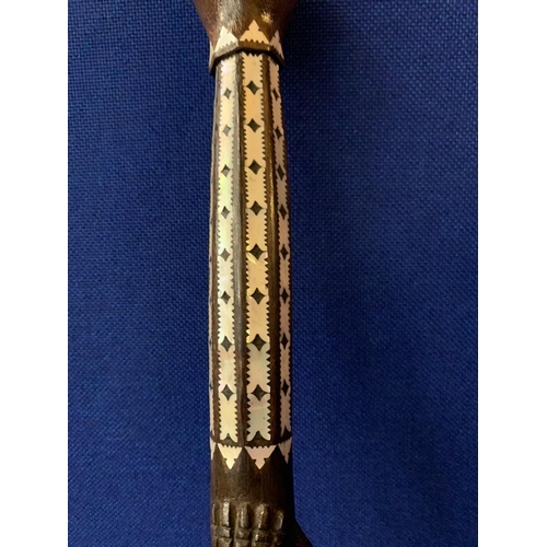 40 - AN INTRICATELY CARVED WOODEN STICK WITH MOTHER OF PEARL STYLE DETAIL AND CROCODILE AND SNAKE DESIGN