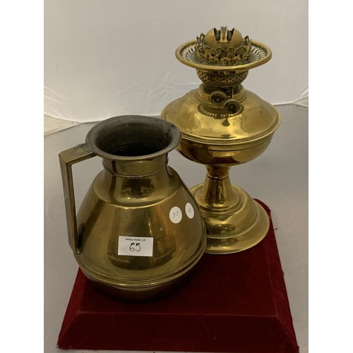 65 - A LARGE BRASS JUG AND A BRASS OIL LAMP BASE