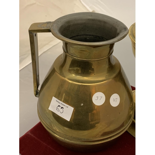 65 - A LARGE BRASS JUG AND A BRASS OIL LAMP BASE