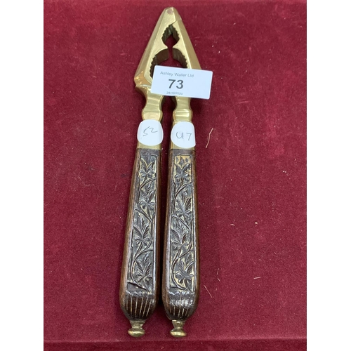 73 - A PAIR OF CARVED WOOD AND BRASS VINTAGE NUT CRACKERS