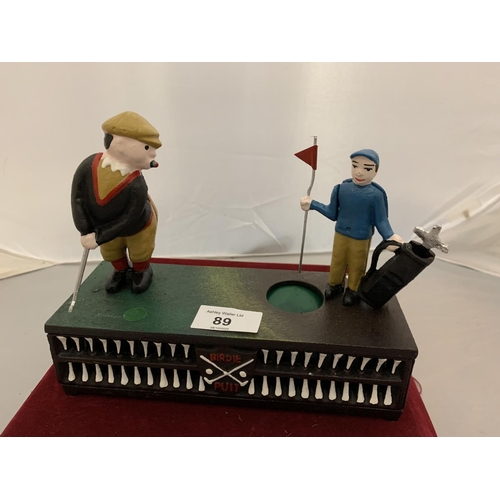 89 - A CAST IRON MONEY BOX WITH A MOVABLE GOLFER AND CADDY