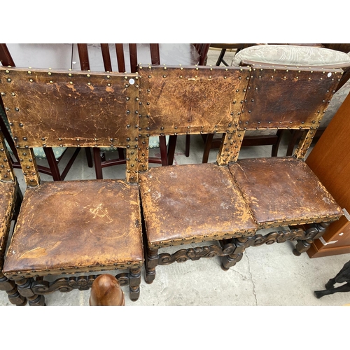 1857 - A SET OF SIX CARVED OAK DINING CHAIRS WITH STUDDED LEATHER SEATS AND BACKS (INCLUDING ONE CARVER)