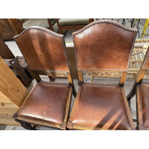 1933 - A SET OF FOUR EARLY 20TH CENTURY OAK DINING CHAIRS WITH LEATHER SEATS AND BACKS WITH STUDDED DECORAT... 