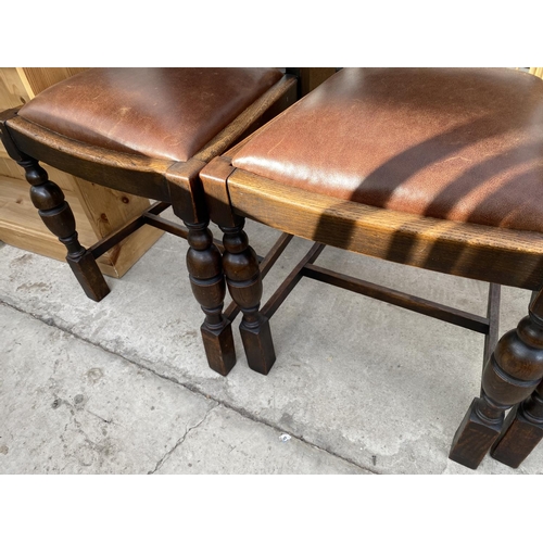 1933 - A SET OF FOUR EARLY 20TH CENTURY OAK DINING CHAIRS WITH LEATHER SEATS AND BACKS WITH STUDDED DECORAT... 