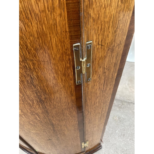 1940 - A GEORGE III OAK AND CROSSBANDED BOWFRONT CORNER CUPBOARD WITH H BRASS HINGE, 30