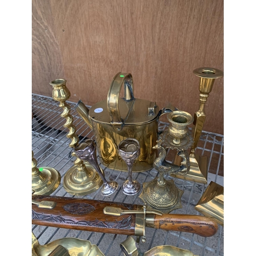 1225 - A LARGE QUANTITY OF BRASS ITEMS TO INCLUDE SEVERAL CANDLE STICK HOLDERS, BRASS KETTLE, AN ORNATE IND... 