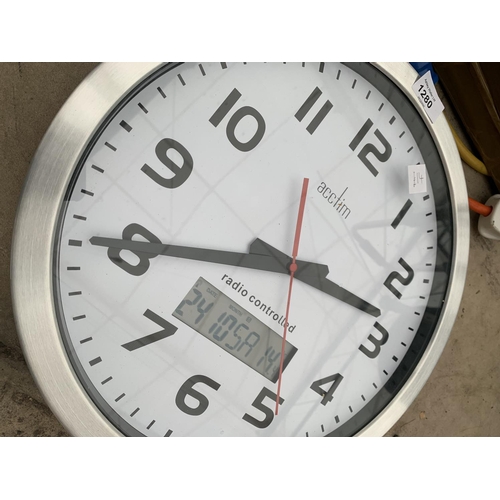 1280 - A LARGE RADIO CONTROLLED CLOCK, A 110V EXTENSION LEAD AND FURTHER EXTENSION LEADS