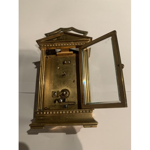 630 - A BRASS CARRIAGE CLOCK WITH  GABLED TOP WITH GLASS VIEWING PANE, FRENCH MECHANICAL MOVEMENT AND KEY