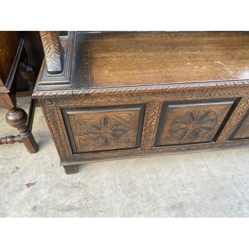 2137 - AN EARLY 20TH CENTSURY OAK MONKS BENCH WITH CARVED THREE PANEL FRONT, 43