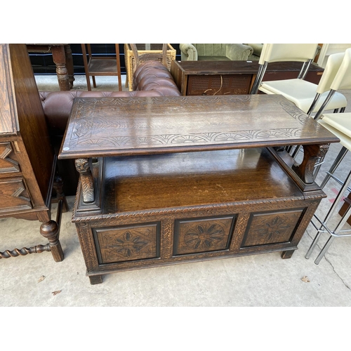 2137 - AN EARLY 20TH CENTSURY OAK MONKS BENCH WITH CARVED THREE PANEL FRONT, 43