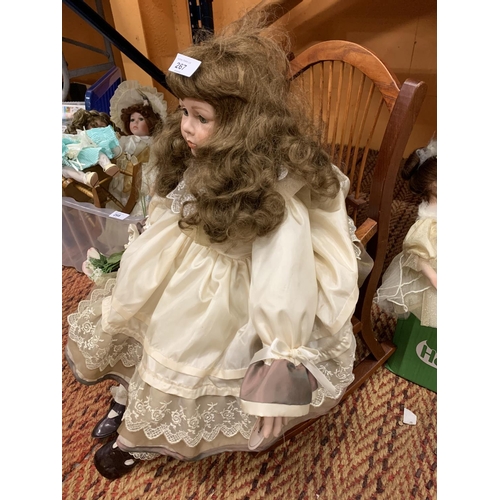 267 - A LARGE PORCELAIN HEADED DOLL CALLED ALISON IN A WOODEN ROCKING CHAIR