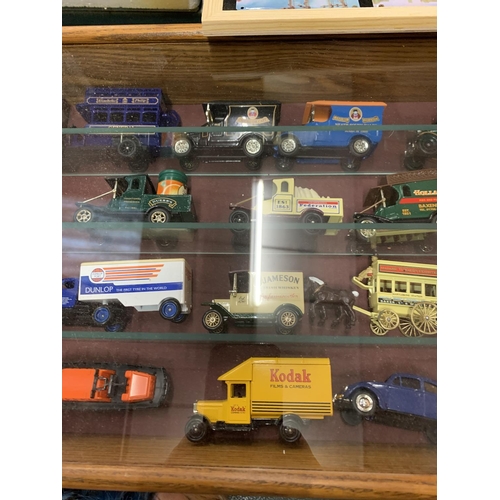 483 - AN ASSORTMENT OF DIE CAST MODEL REPLICA VEHICLES IN A DISPLAY CASE TO INCLUDE A 'JAMESON' VAN AND A ... 