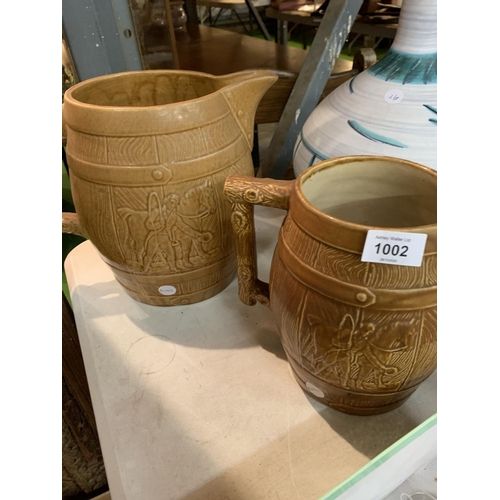 1002 - TWO LARGE POTTERY JUGS IN A BARREL STYLE