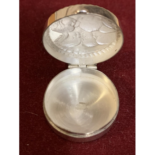 653 - A SMALL ROUND SILVER HINGED VINTAGE PILL BOX