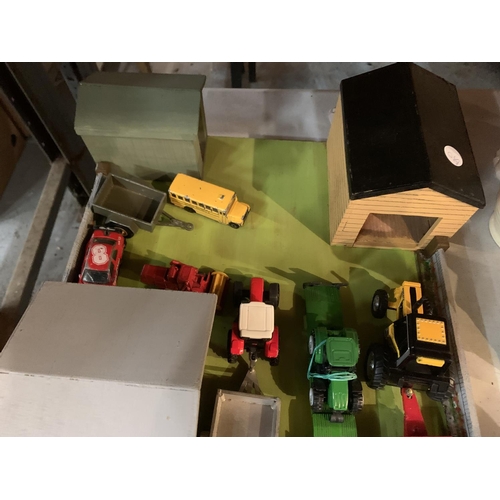 973 - A WOODEN FARM YARD LAYOUT WITH SHEDS AND DIECAST VEHICLES TO INCLUDE A JOHN DEERE LOW LOADER WAGON A... 