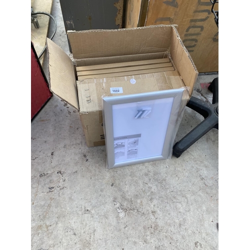 1602 - A BOX OF NEW PICTURE FRAMES AND A REVOLVING MAGAZINE STAND