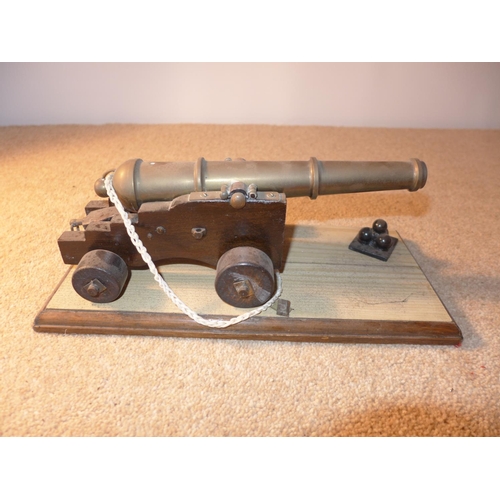 379 - A BRASS BARRELED MODEL OF AN EARLY 19TH NAVAL CANNON, MOUNTED ON A WOODEN CARRAIGE, LENGTH OF BARREL... 