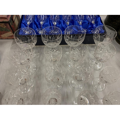 113 - AN ASSORTMENT OF CUT GLASSES TO INCLUDE SIX BOXED CHAMPAGNE FLUTES ETC