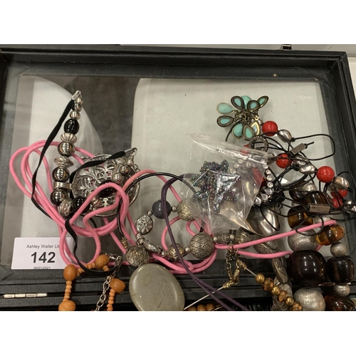 142 - A MODERN DISPLAY CASE CONTAINING AN ASSORTMENT OF COSTUME JEWELLERY