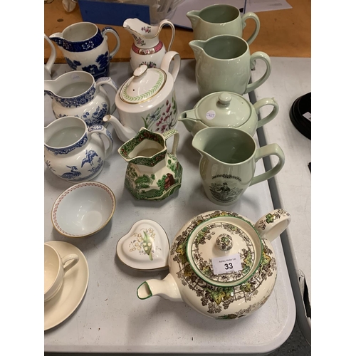 33 - A LARGE ASSORTMENT OF COPELAND SPODE TEAPOTS AND JUGS TO INCLUDE ROYAL DOULTON EXAMPLES