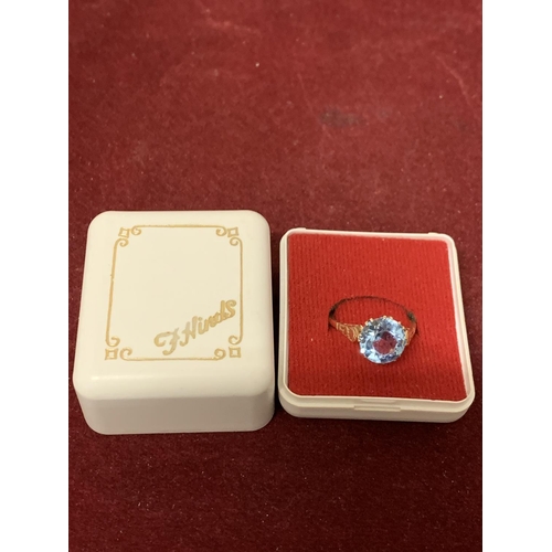 592 - A 9 CARAT GOLD RING WITH A  PALE BLUE STONE 3.21G