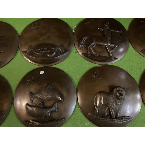 659 - TWELVE CIRCULAR RESIN WALL PLAQUES DEPICTING THE SIGNS OF THE ZODIAC (ONE A/F)