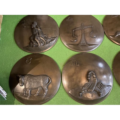 659 - TWELVE CIRCULAR RESIN WALL PLAQUES DEPICTING THE SIGNS OF THE ZODIAC (ONE A/F)