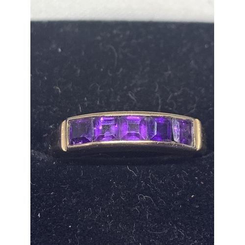 520 - A 9 CARAT GOLD RING MARKED 375 WITH FIVE IN LINE PURPLE STONES SIZE M GROSS WEIGHT APPROXIMATELY 2.9... 