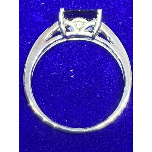 537 - A SILVER RING MARKED 925 WITH A SINGLE DARK BLUE/PURPLE STONE AND CLEAR STONES ON THE SHOULDERS SIZE... 