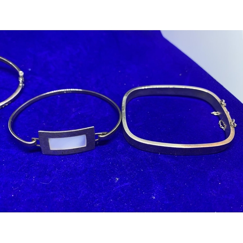 571 - FOUR SILVER BANGLES MARKED 925 ONE WITH GRECIAN DESIGN, ONE WITH CLEAR STONES ETC