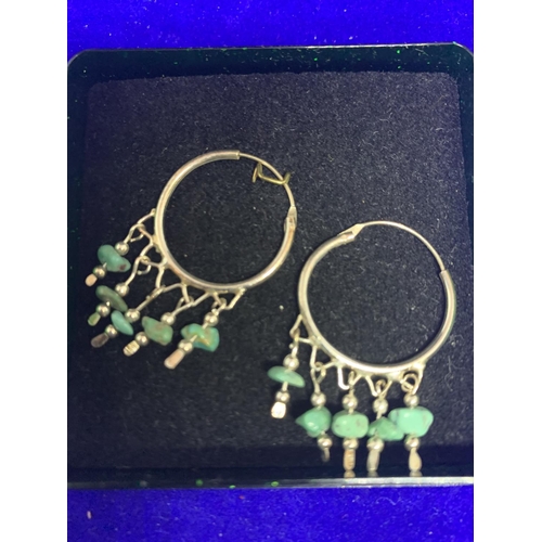 585 - A PAIR OF SILVER HOOP EARRINGS WITH JADE STYLE STONES AND A DECORATIVE SILVER PENDANT IN A PRESENTAT... 