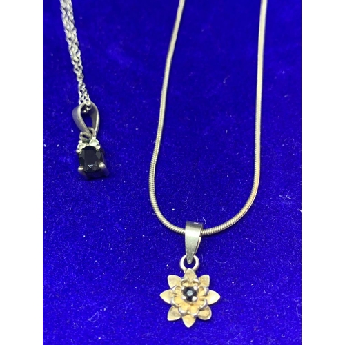 596 - FOUR SILVER NECKLACES MARKED 925 WITH PENDANTS TO INCLUDE A CLEARSTONE, FLOWER ETC