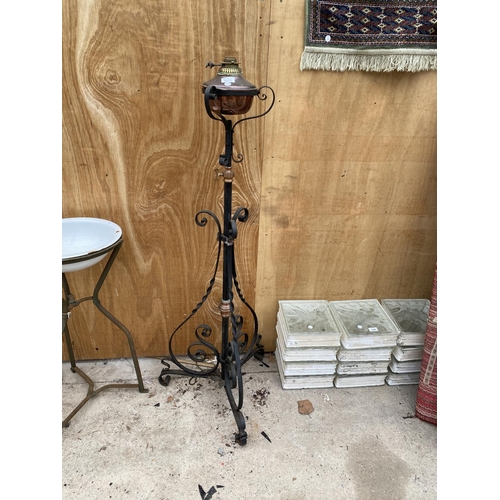 1211 - A DECORATIVE BRASS AND COPPER OIL LAMP ON A TALL DECORATIVE BLACK CAST IRON METAL STAND (H:137CM)