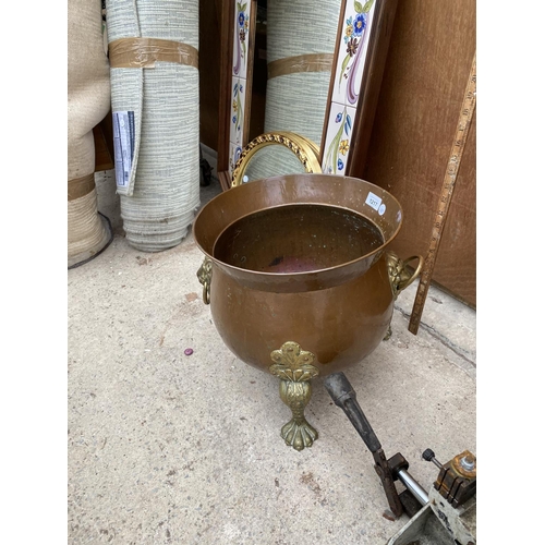 1217 - A BRASS AND COPPER CAULDRON WITH DECORATIVE CLAW FEET AND LION HEAD HANDLES