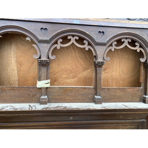 1254 - A LARGE ORNATE WOODEN FIRE SURROUND WITH DECORATIVE CARVING