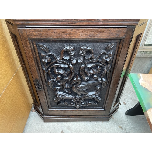 1904 - A LATE VICTORIAN OAK CORNER CUPBOARD WITH HEAVILY CARVED SINGLE DOOR AND SHAPED INTERIOR SHELF, 26