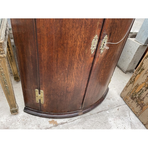 1907 - A GEORGE III OAK BOWFRONTED CORNER CUPBOARD, 29