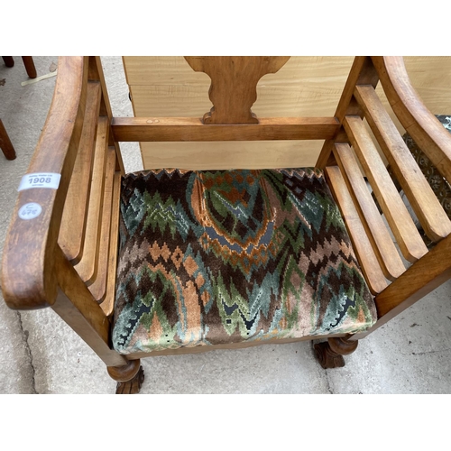 1908 - AN EARLY 20TH CENTURY WALNUT FRAMED LOW ELBOW CHAIR ON TURNED BULBOUS LEGS AND SCROLL FEET