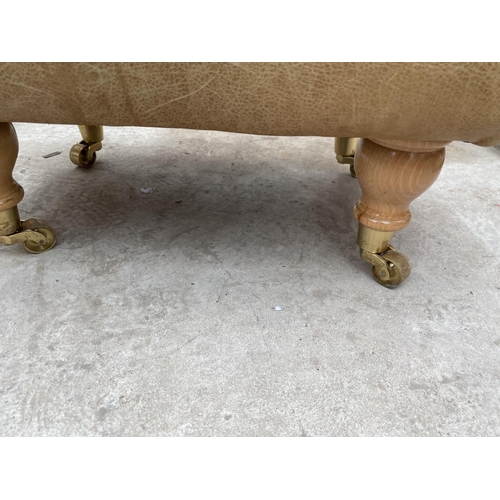 1928 - A MODERN LEATHER FOOT STOOL ON TURNED LEGS, COMPLETE WITH BRASS CASTORS