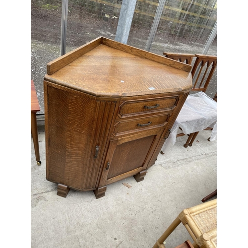 1937 - AN EARLY 20TH CENTURY OAK CORNER CABINET ENCLOSING THREE CUPBOARDS AND TWO DRAWERS, 42