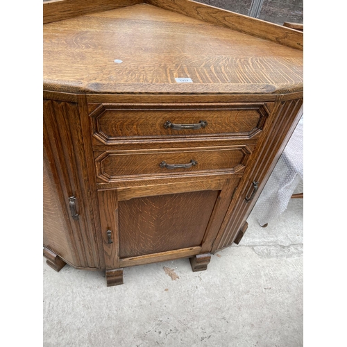 1937 - AN EARLY 20TH CENTURY OAK CORNER CABINET ENCLOSING THREE CUPBOARDS AND TWO DRAWERS, 42