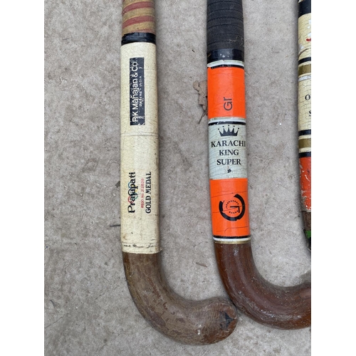 1323 - FOUR VINTAGE HOCKEY STICKS