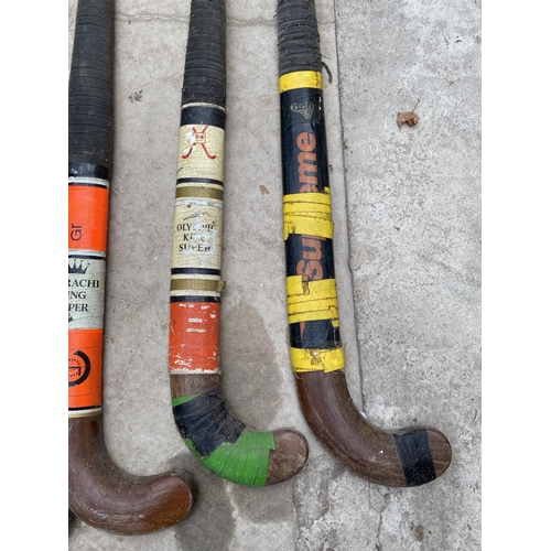 1323 - FOUR VINTAGE HOCKEY STICKS