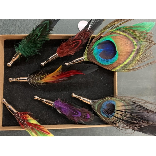 91 - A COLLECTION OF SEVEN LAPEL PINS IN THE FORM OF COLOURFUL FEATHERS