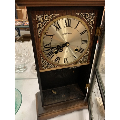 139 - A HIGHLANDS 31 DAY WALL CLOCK WITH PENDULUM AND KEY (FINIALS INSIDE CLOCK FOR REATTACHING)